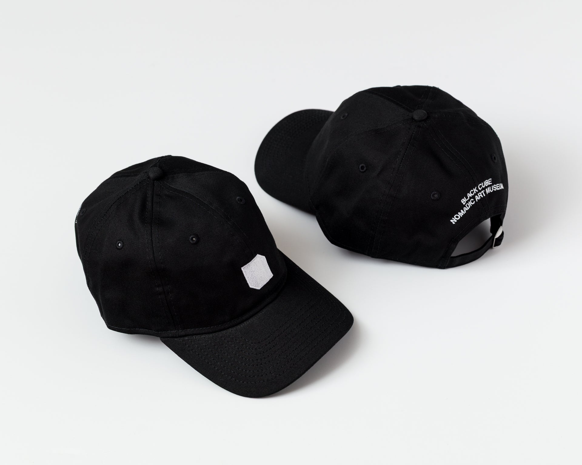 Two black baseball caps on a white background